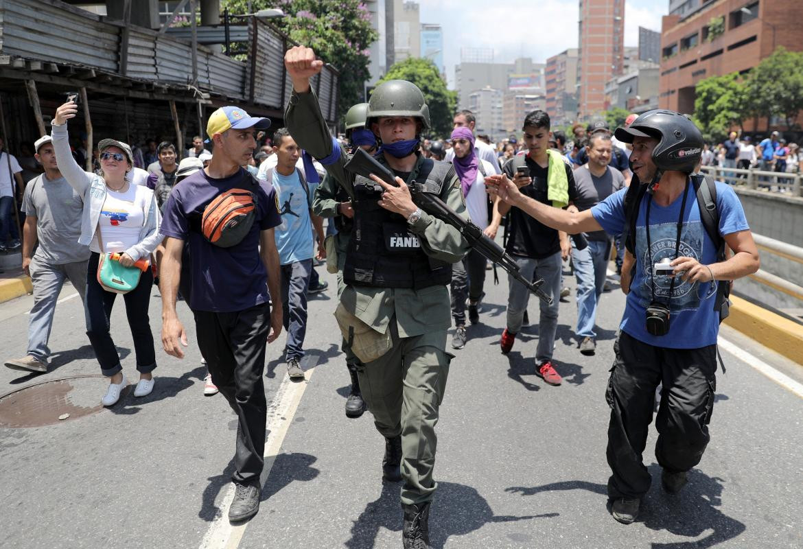 Un miembro de la Guardia Nacional venezolana hace gestos, luego de unirse a manifestantes antigubernamentales en una marcha, mostrando su apoyo al líder de la oposición Juan Guaido en Caracas, Reuters