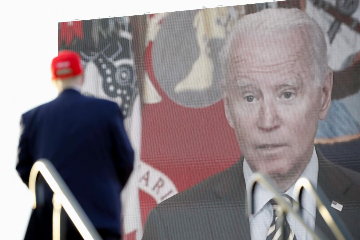 El presidente de los Estados Unidos, Joe Biden en pantalla mientras Trump habla en campaña en elecciones de mitad de período_Foto Reuters