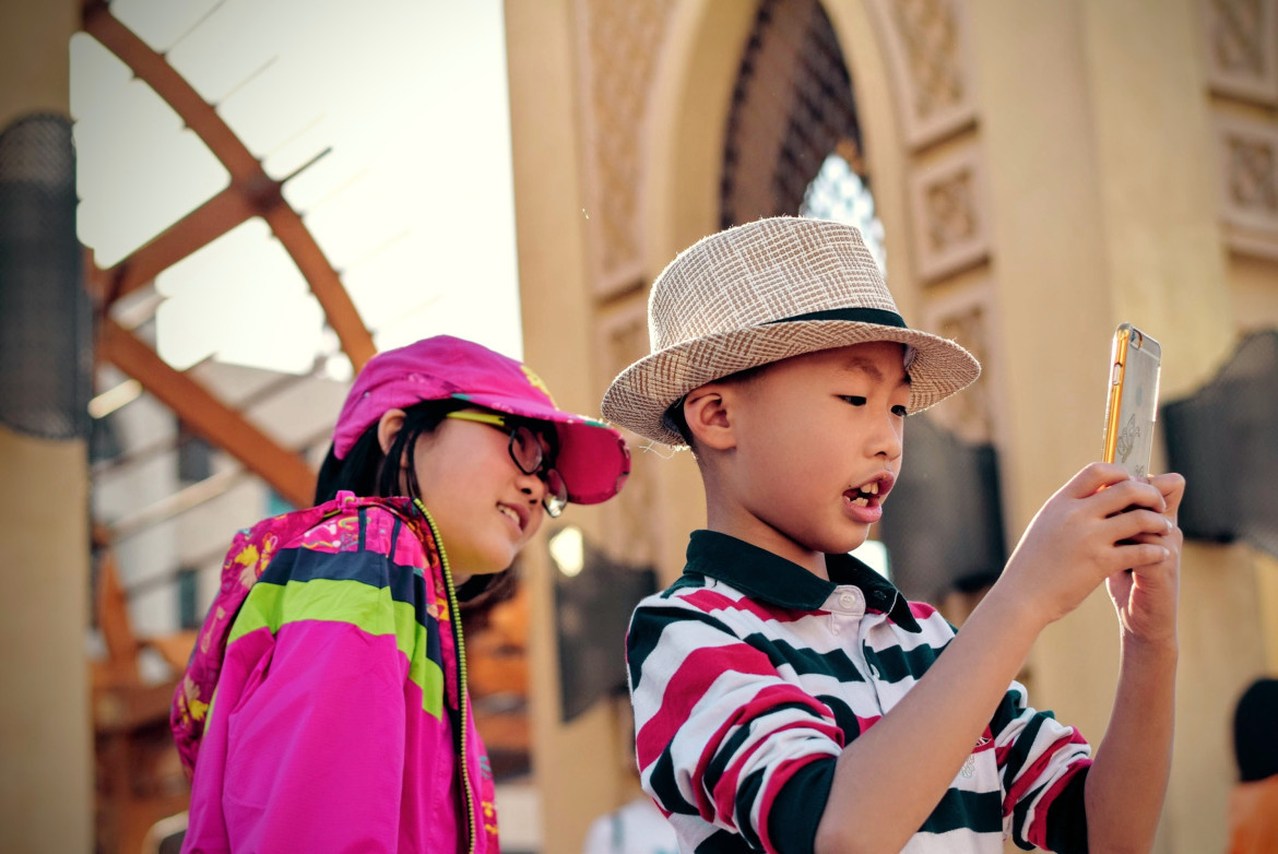 Niño con celular. Foto: Unsplash.