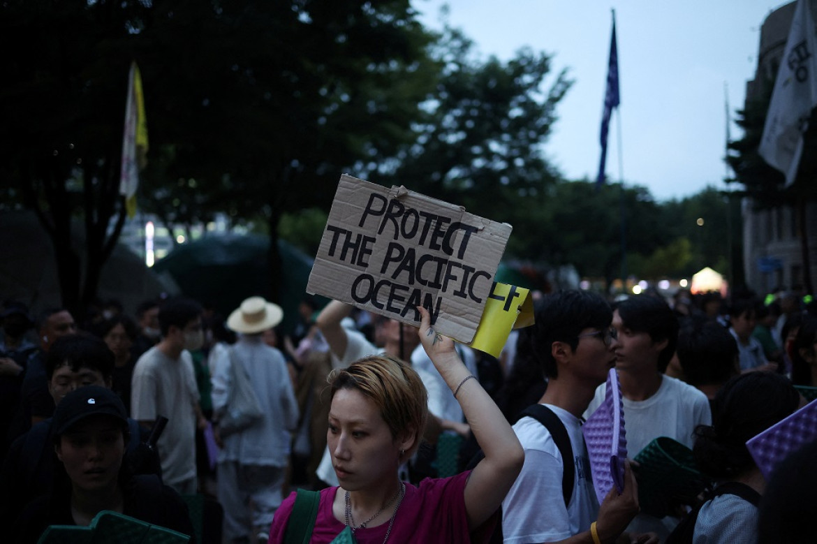 Una mujer sostiene una pancarta durante una protesta contra el plan de Japón de liberar al océano aguas residuales tratadas de la central nuclear de Fukushima. Foto: Reuters.