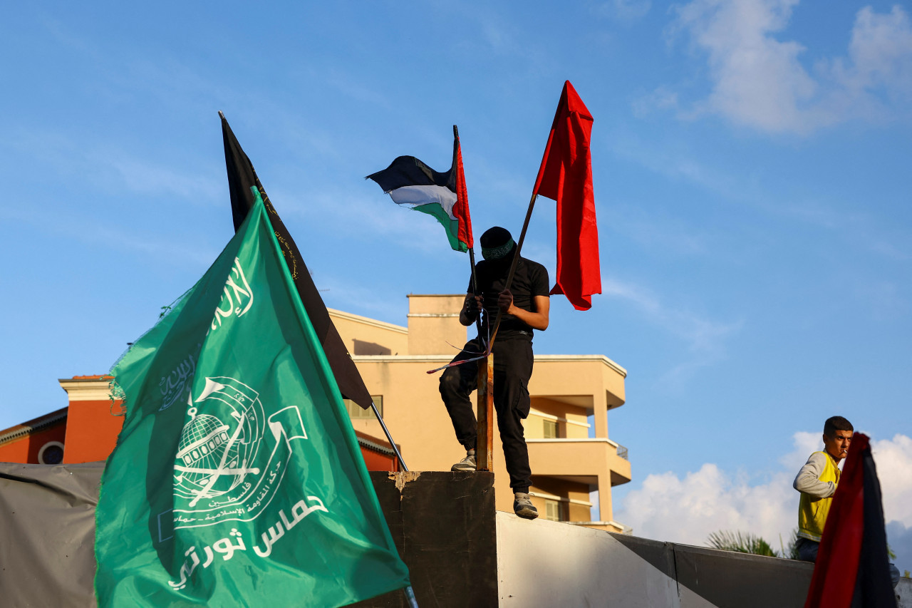 hombre sostiene banderas durante protesta en apoyo de los palestinos en Gaza, en Beirut, Líbano. Reuters