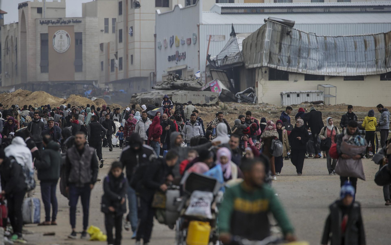 Los palestinos desplazados internos pasan junto a los tanques israelíes después de que el ejército israelí dijera a los residentes del campamento de Khan Yunis que abandonaran sus hogares. Foto: EFE