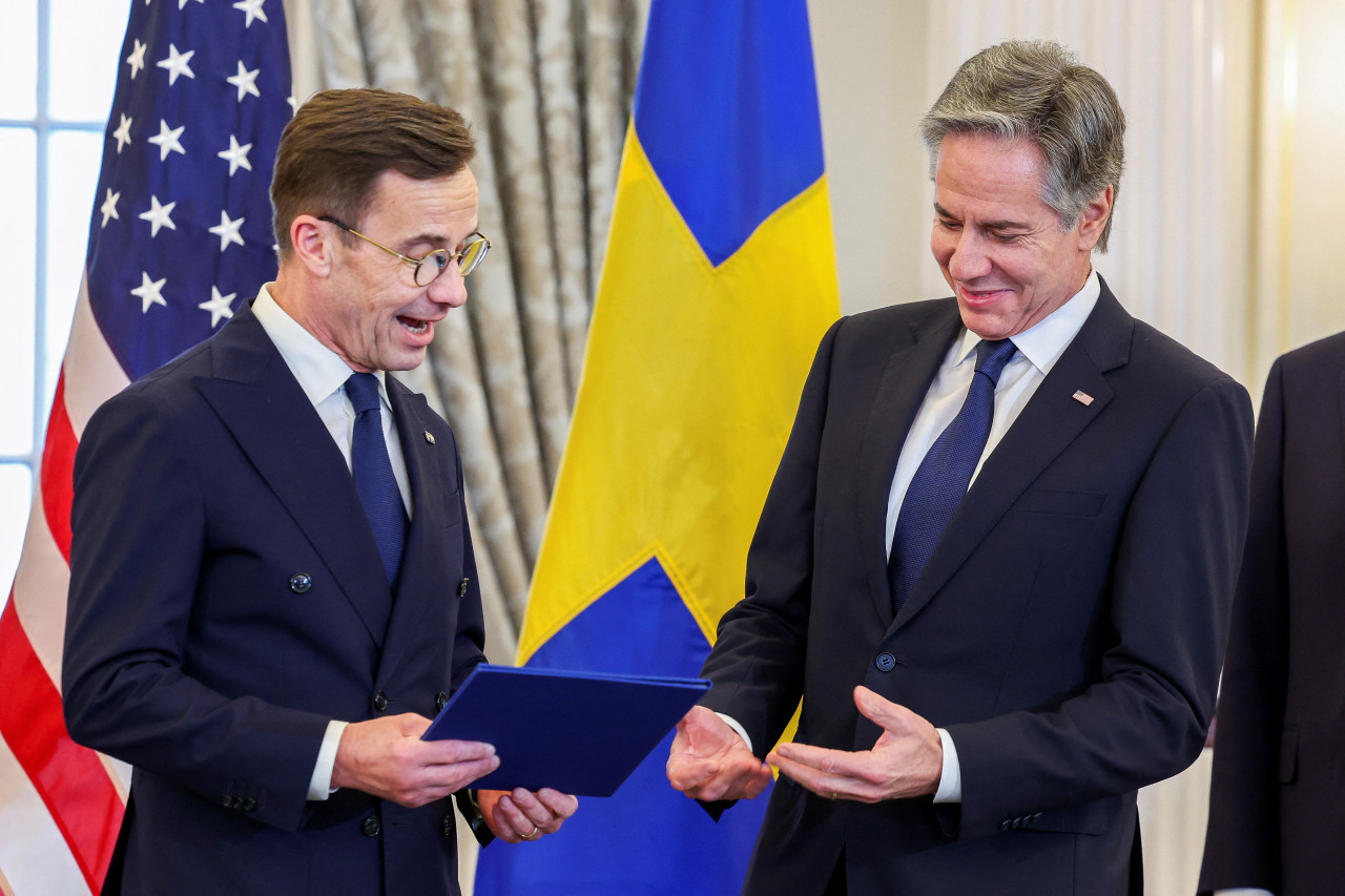 Ulf Kristersson, primer ministro sueco, haciendo entrega del instrumento de acceso a la OTAN a Antony Blinken. Foto: REUTERS.