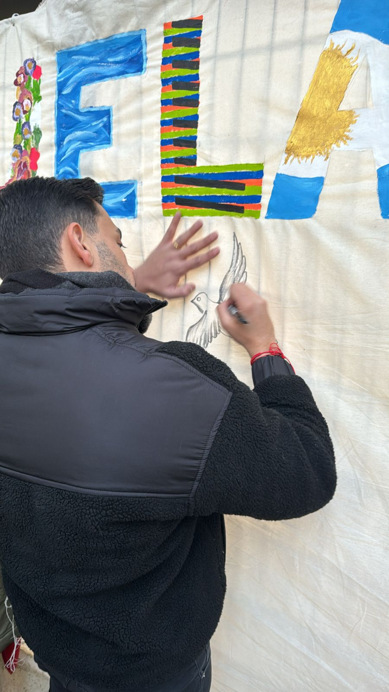 Venezolanos en Argentina firman el mural después de votar. Foto: Gabriel Bastidas