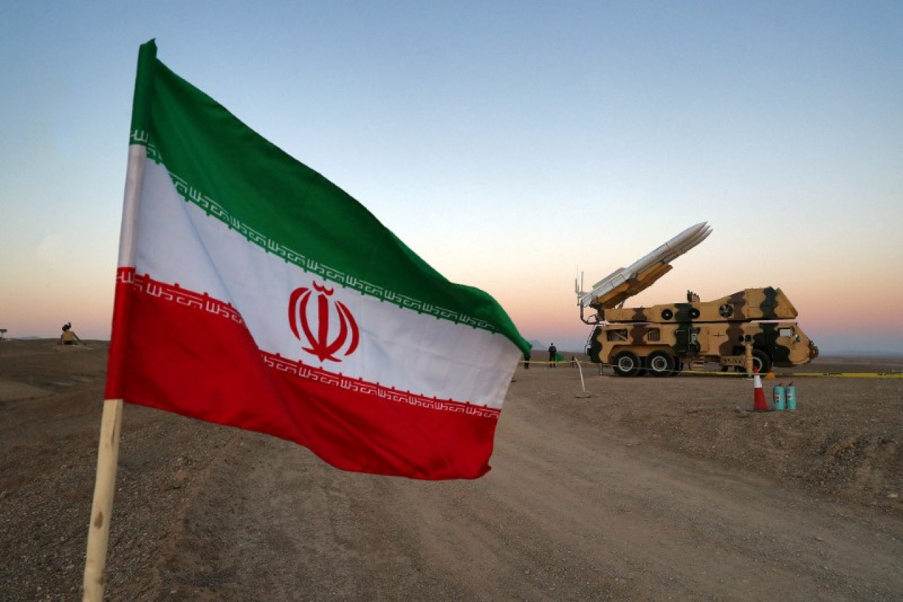 Una bandera iraní es fotografiada cerca de un misil. Foto: Reuters.