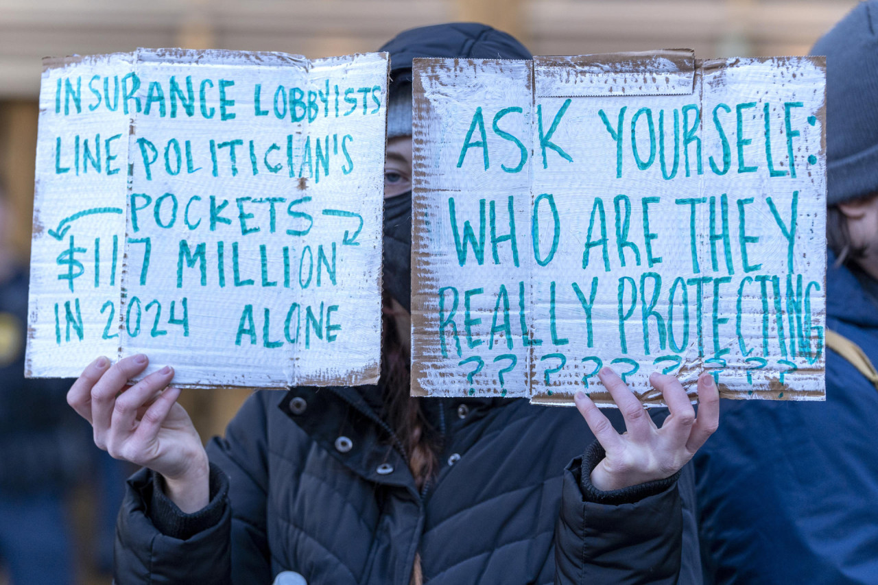 Carteles durante una protesta frente al tribunal federal de Manhattan, donde leyeron las acusaciones de Mangione. Foto: EFE/ Ángel Colmenares.