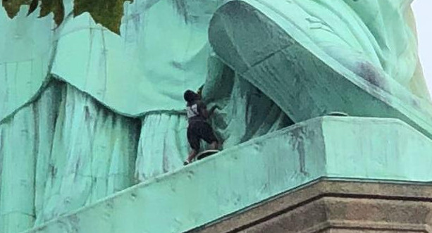 Mujer protesta en la Estatua de la Libertad, Reuters