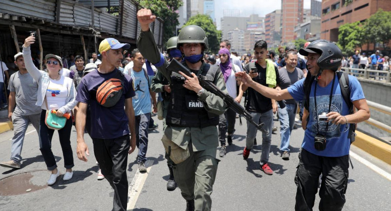 Un miembro de la Guardia Nacional venezolana hace gestos, luego de unirse a manifestantes antigubernamentales en una marcha, mostrando su apoyo al líder de la oposición Juan Guaido en Caracas, Reuters