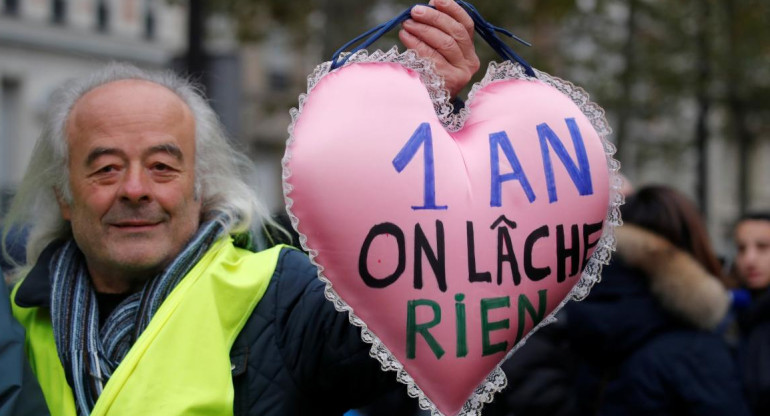 Un manifestante sostiene una almohada en forma de corazón con el lema "1 año y no renunciamos", Chalecos amarillos, Francia, REUTERS