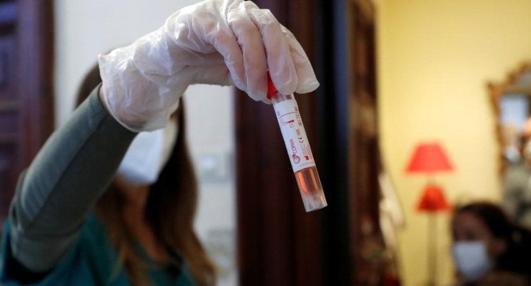 Trabajadora médica sostiene frasco mientras visita un hogar de pacientes sospechosos de padecer covid-19 en Roma, Italia, el 3 de diciembre de 2020, Reuters