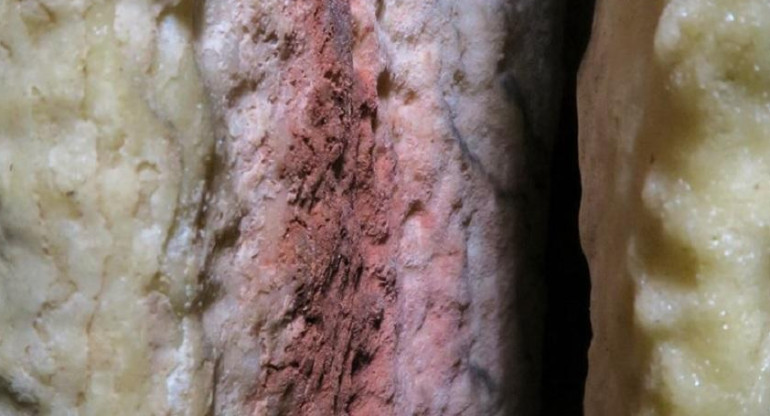 Marcas rojas encontradas en una estalagmita en la caverna de Ardales (en Málaga, España), que podrían ser las pinturas rupestres más antiguas del mundo conocidas hasta ahora. Imagen cedida por la Universidad de Cádiz.