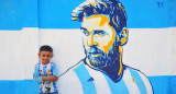 En Bangladesh. Un niño posa en la calle junto a un retrato graffiti de su ídolo, Lionel Messi. Foto Reuters