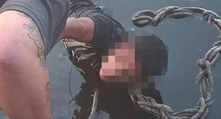 Momento que lo ayudan a salir del agua. Foto: captura de video.