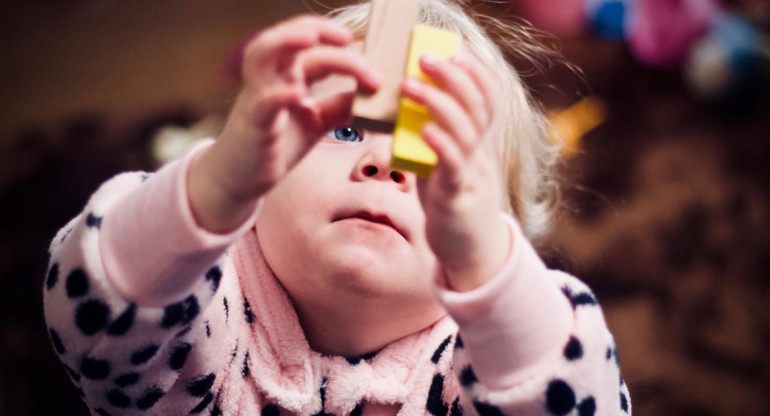 Bebé jugando con bloques de madera. Foto: Unsplash