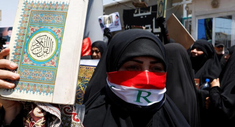 Una mujer muestra un Corán durante una protesta. Foto: Reuters.