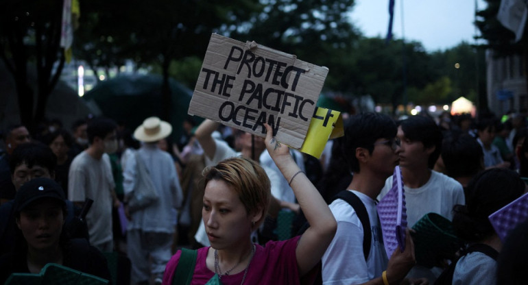 Una mujer sostiene una pancarta durante una protesta contra el plan de Japón de liberar al océano aguas residuales tratadas de la central nuclear de Fukushima. Foto: Reuters.