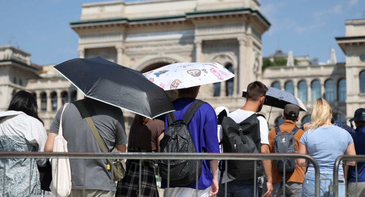 La gente usa sombrillas para esconderse del sol, mientras hacen cola para entrar en la Catedral del Duomo de Milán, durante una ola de calor. Foto: Reuters.