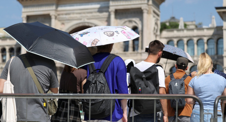 La gente usa sombrillas para esconderse del sol, mientras hacen cola para entrar en la Catedral del Duomo de Milán, durante una ola de calor. Foto: Reuters.