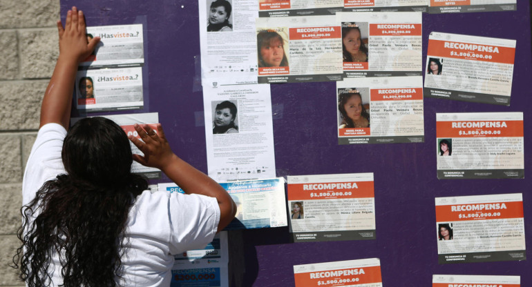 Madres pegando fotos de los migrantes desaparecidos en forma de protesta. Foto: EFE