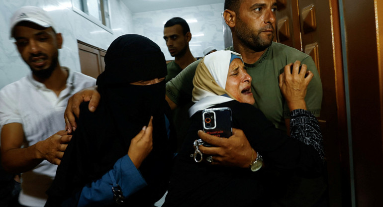 Familia palestina tras el asesinato de su hijo en la frontera con Gaza en manos de las fuerzas israelíes. Foto: Reuters.
