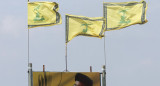 Las banderas de Hezbollah ondean sobre un cartel que representa al líder Sayyed Hassan Nasrallah. Foto: Reuters.