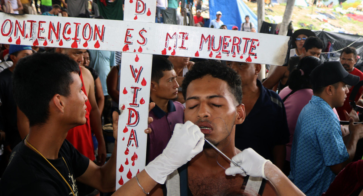Los migrantes se cosieron los labios como muestra de reclamo. Foto: EFE.