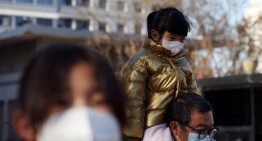 Aumentan los casos de neumonía en China. Un hombre carga a su hijo hacía el hospital. Reuters.