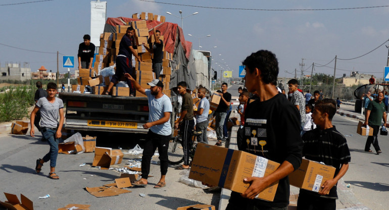 Palestinos recibiendo paquetes de ayuda humanitaria. Gaza. Reuters.