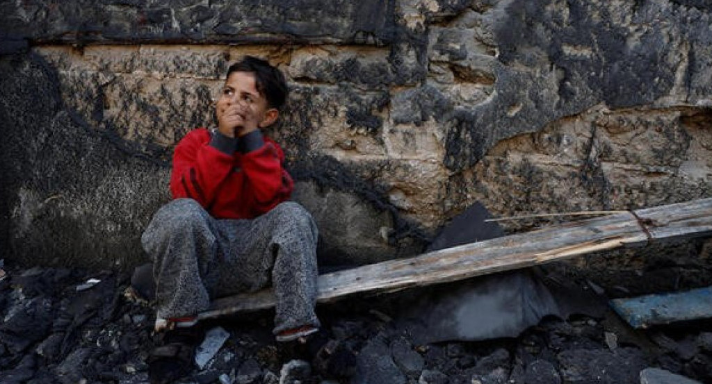 un niño palestino sentado junto a unos escombros en Jan Yunis, en el sur de la Franja de Gaza.. Reuters