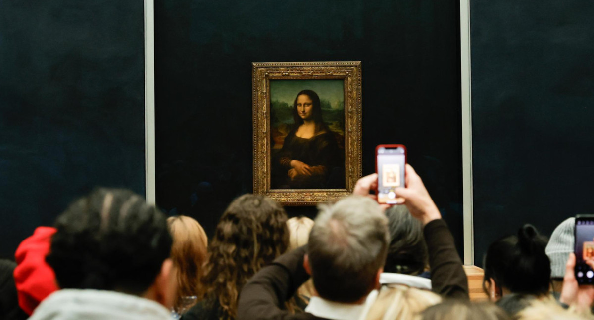 Visitantes toman fotografías de la Mona Lisa del pintor italiano Leonardo Da Vinci en el Museo del Louvre en París, Francia. EFE