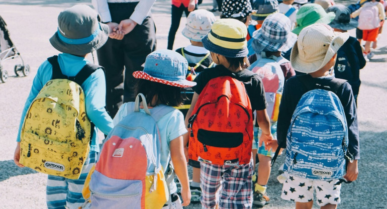 Niños pequeños con mochilas. Foto: Unsplash.