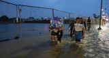 Personas caminan por una vía inundada debido a fuertes lluvias en Guayaquil, Ecuador. Foto: EFE.