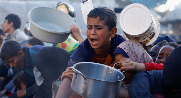 Niños palestinos esperan recibir alimentos durante el Ramadán, en Rafah. Efe
