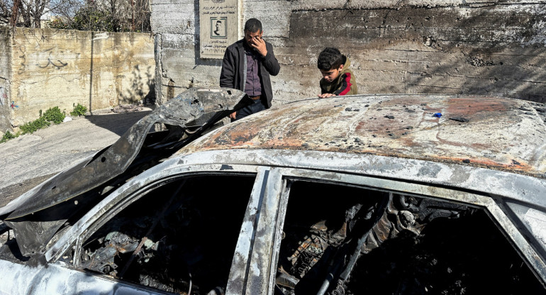 Palestinos revisan un coche dañado tras un ataque de colonos israelíes. Foto: Reuters