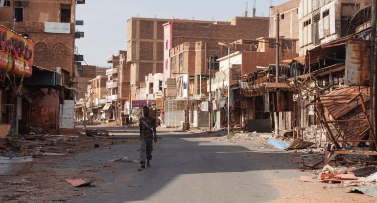 Miembro de las Fuerzas Armadas Sudanesas camina entre edificios dañados, casi un año después del inicio de la guerra entre las Fuerzas Armadas Sudanesas y las Fuerzas de Apoyo Rápido (RSF) paramilitares. Reuters