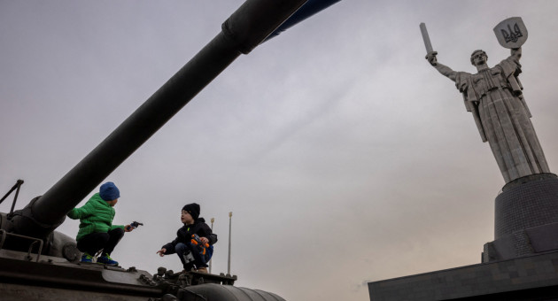 Niños juegan arriba de un tanque en Kiev. Foto: Reuters