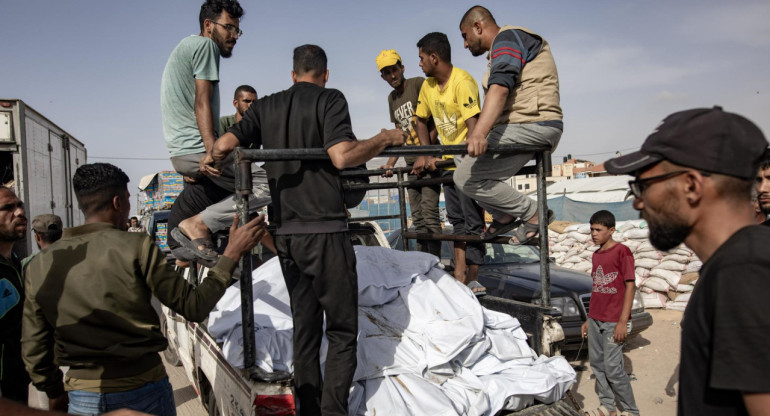 Civiles de Gaza llevan cuerpos en una camioneta tras ataque israelí. Foto: EFE.