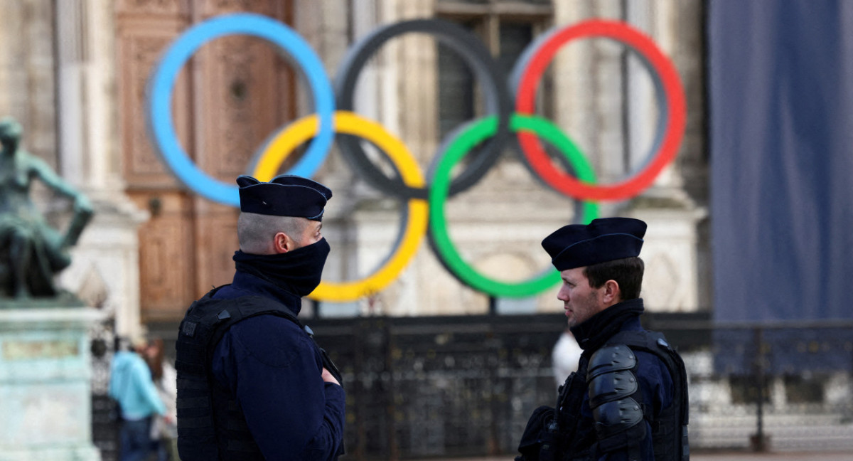 Agentes de Francia hacen guardia cerca de los anillos olímpicos que se exhiben para los Juegos de Verano de París 2024. Foto: Reuters.